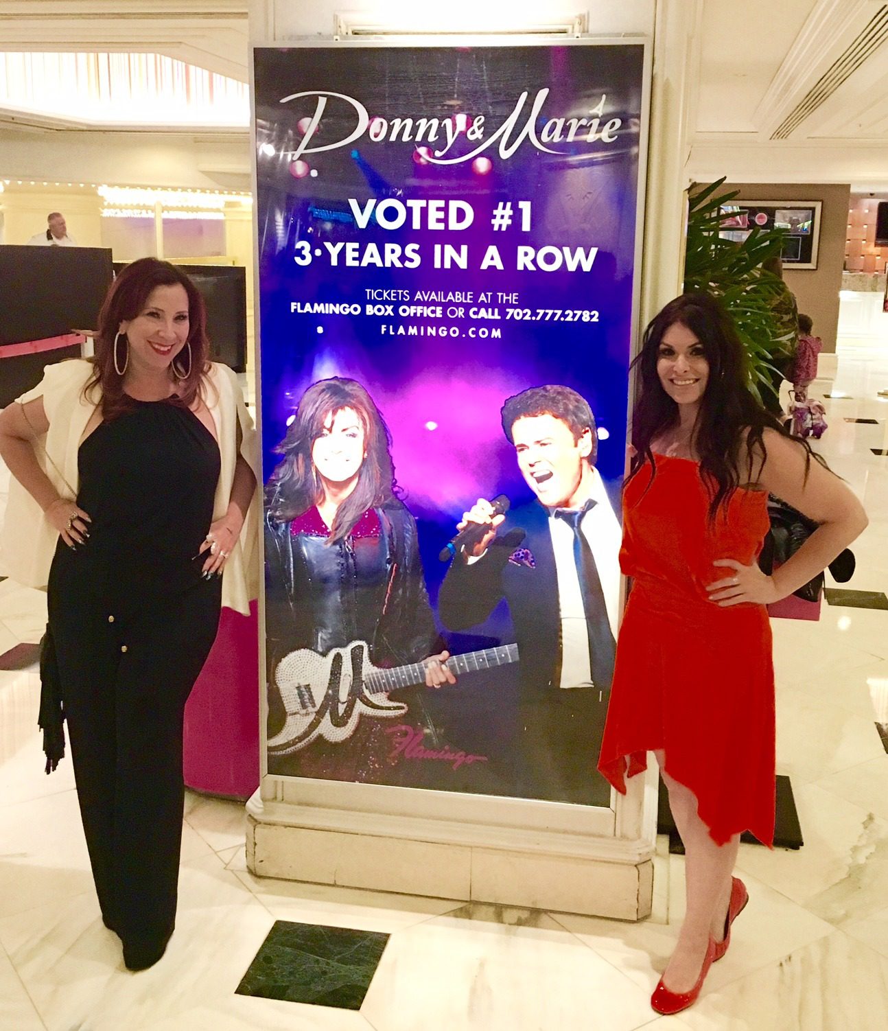2 women in front of a Donny and Marie sign in Las Vegas. 